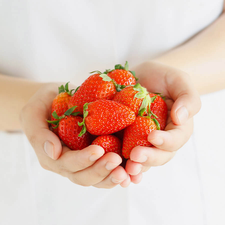 hands holding strawberries